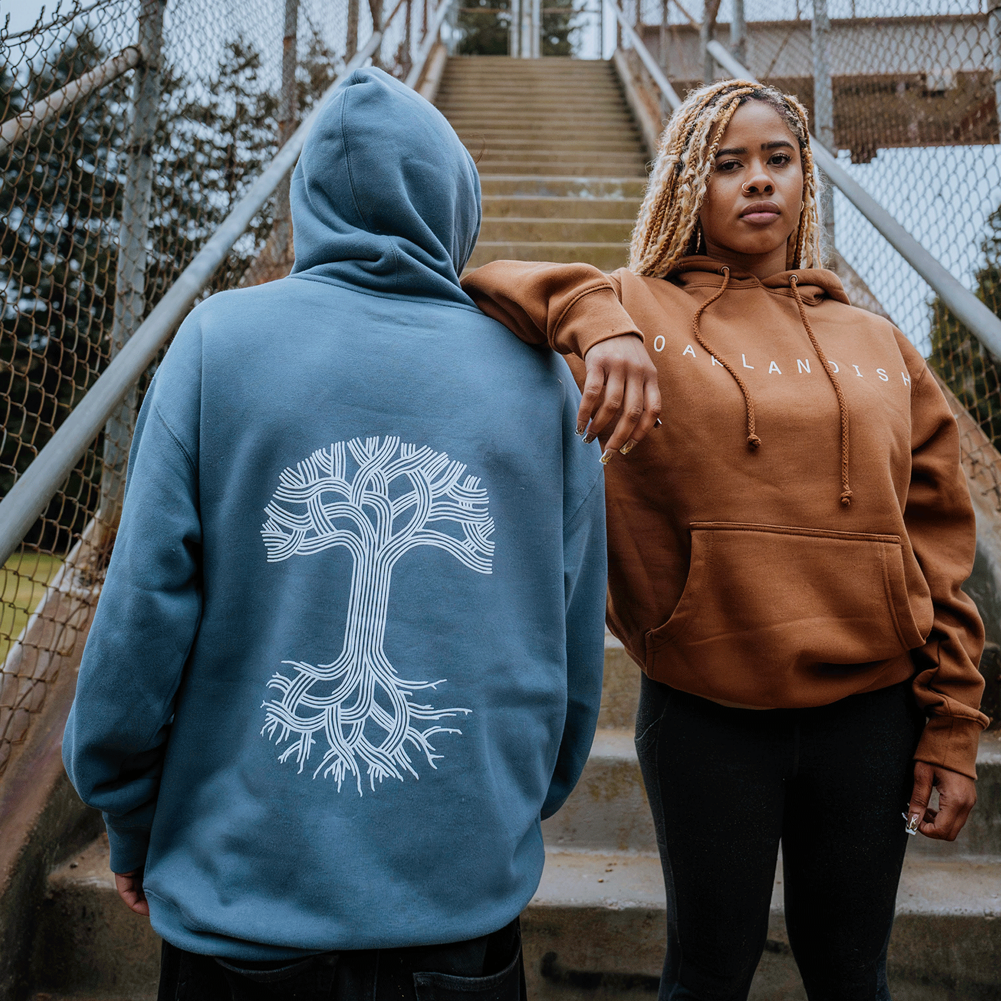 Models wearing classic pullover Hoodie - Classic Oaklandish, Saddle brown & Storm blue..