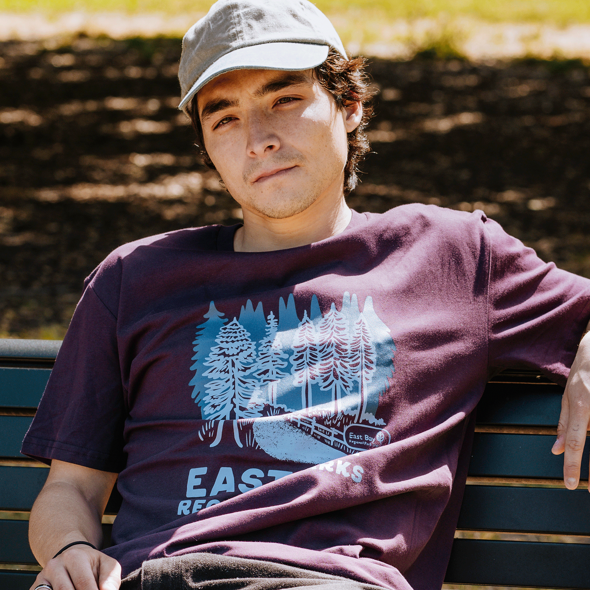 Model wearing plum color cotton t-shirt with East Bay Regional Parks artwork.