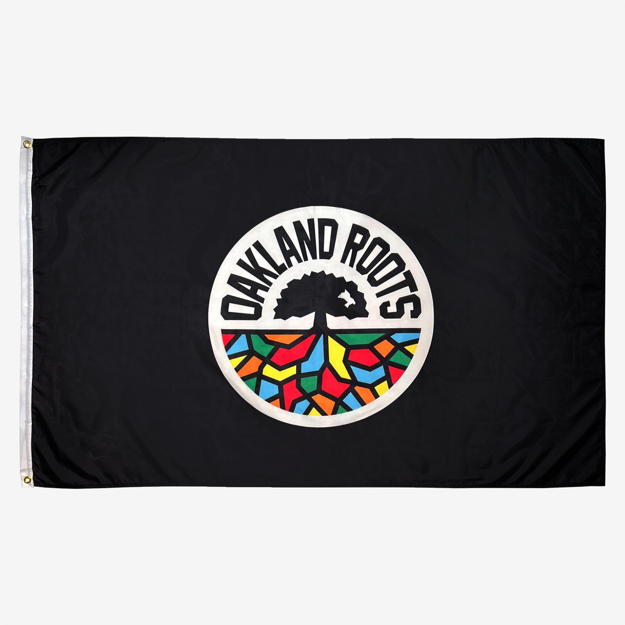 The Oakland Roots SC Logo Flag, branded by Oakland Roots SC, is black and showcases the club's iconic logo. This logo consists of a tree with extensive branches and roots, surrounded by the text "OAKLAND ROOTS." Colorful geometric shapes in red, yellow, blue, and green below the tree symbolize the vibrant roots of the Oakland community.