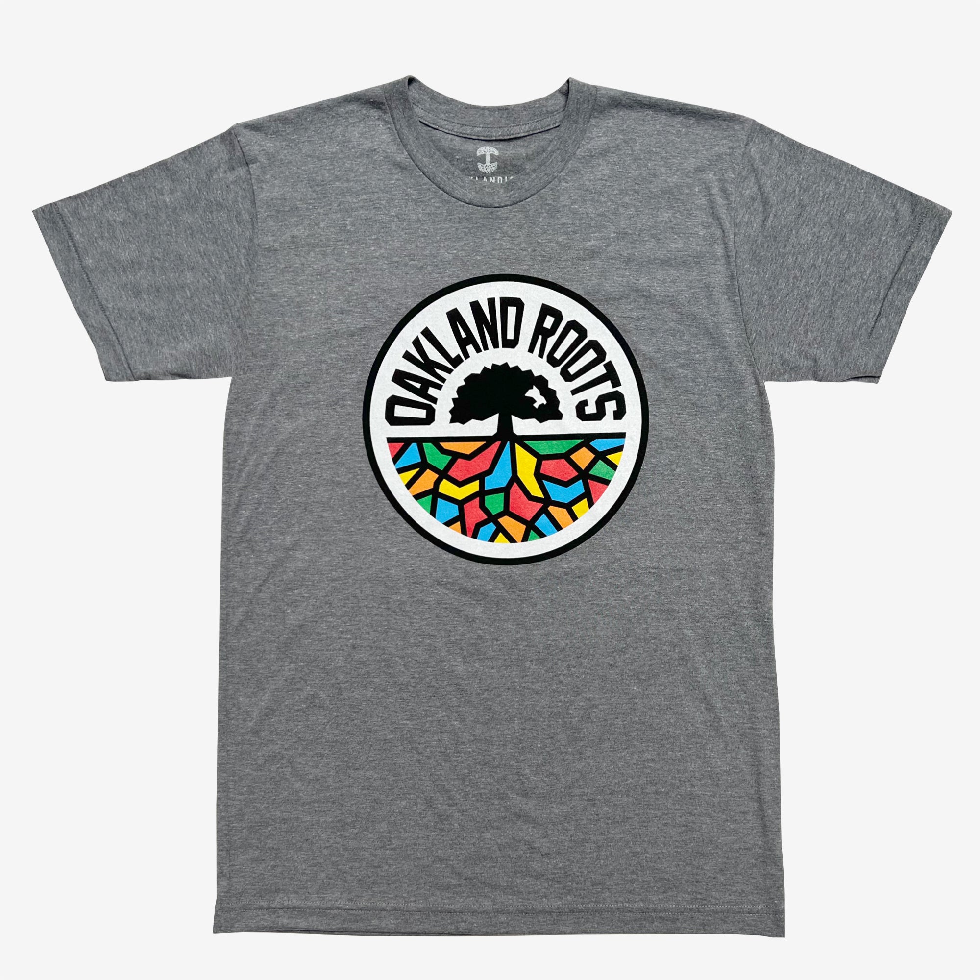 The Oakland Roots SC Classic Tee by Oakland Roots SC features a striking design with a large circular logo at the center. The logo showcases a black tree silhouetted against a vibrant multicolored mosaic background, encircled by the bold text "OAKLAND ROOTS" in black, representing this distinctive sports club. The gray t-shirt comes with short sleeves and a classic crew neckline.