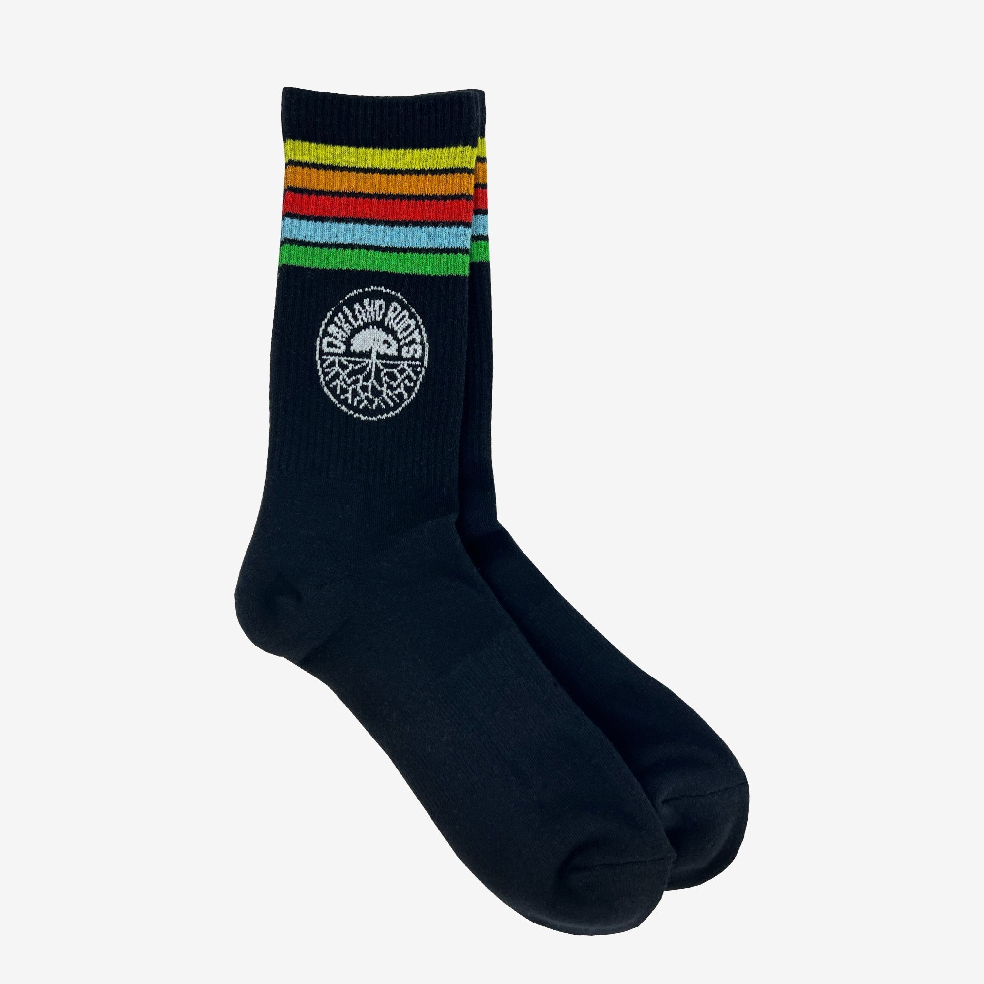 The Oakland Roots SC Stripes Sock by Oakland Roots SC is a pair of black crew socks featuring horizontal decorative stripes around the top in yellow, red, blue, green, and black. Below the stripes is a circular logo with the text "Newland Point" and an intricate graphic design inside the circle. Perfect for sports club enthusiasts.