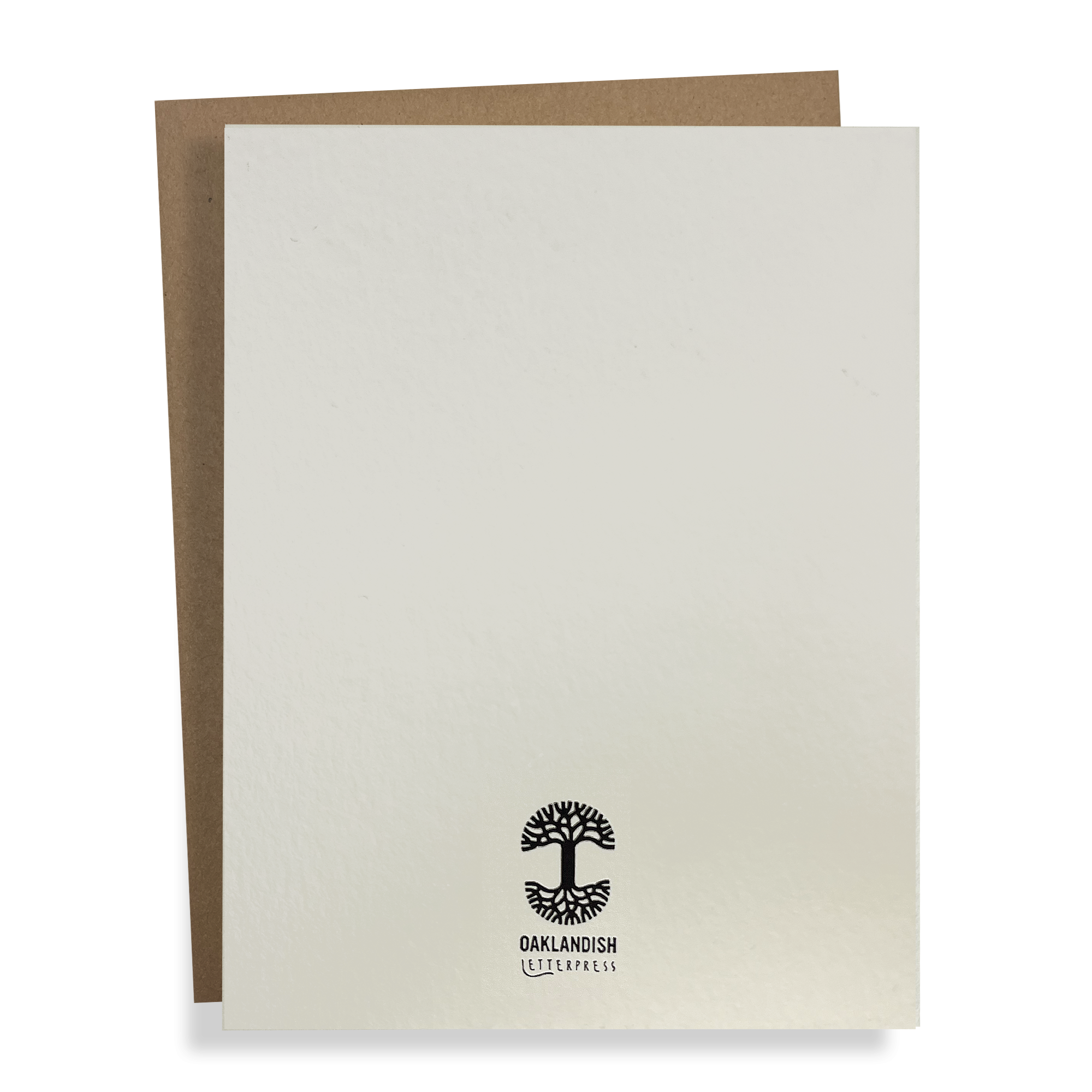 The Oaklandish Pigeon Card by Never Elsewhere features a blank, textured white front cover that partially overlaps a brown envelope. Crafted from recycled paper, the card displays a small black logo at the bottom center featuring an abstract tree with roots and branches, with the text "OAKLANDISH LETTERPRESS" below the tree graphic.