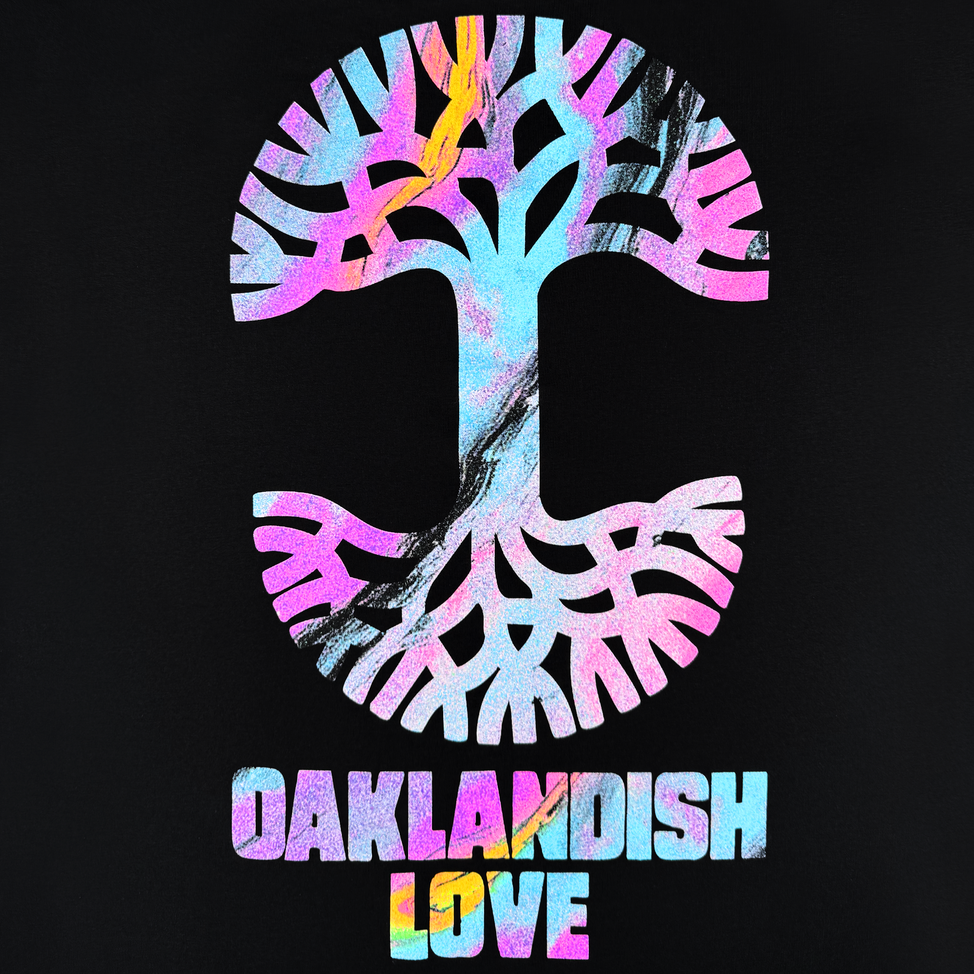 The Almanac X Oaklandish Love Tee features a stylized multicolored tree symbol with pink, blue, and orange tones on a black background. "OAKLANDISH LOVE" is boldly printed below, capturing the essence of a West Oakland Clubhouse.