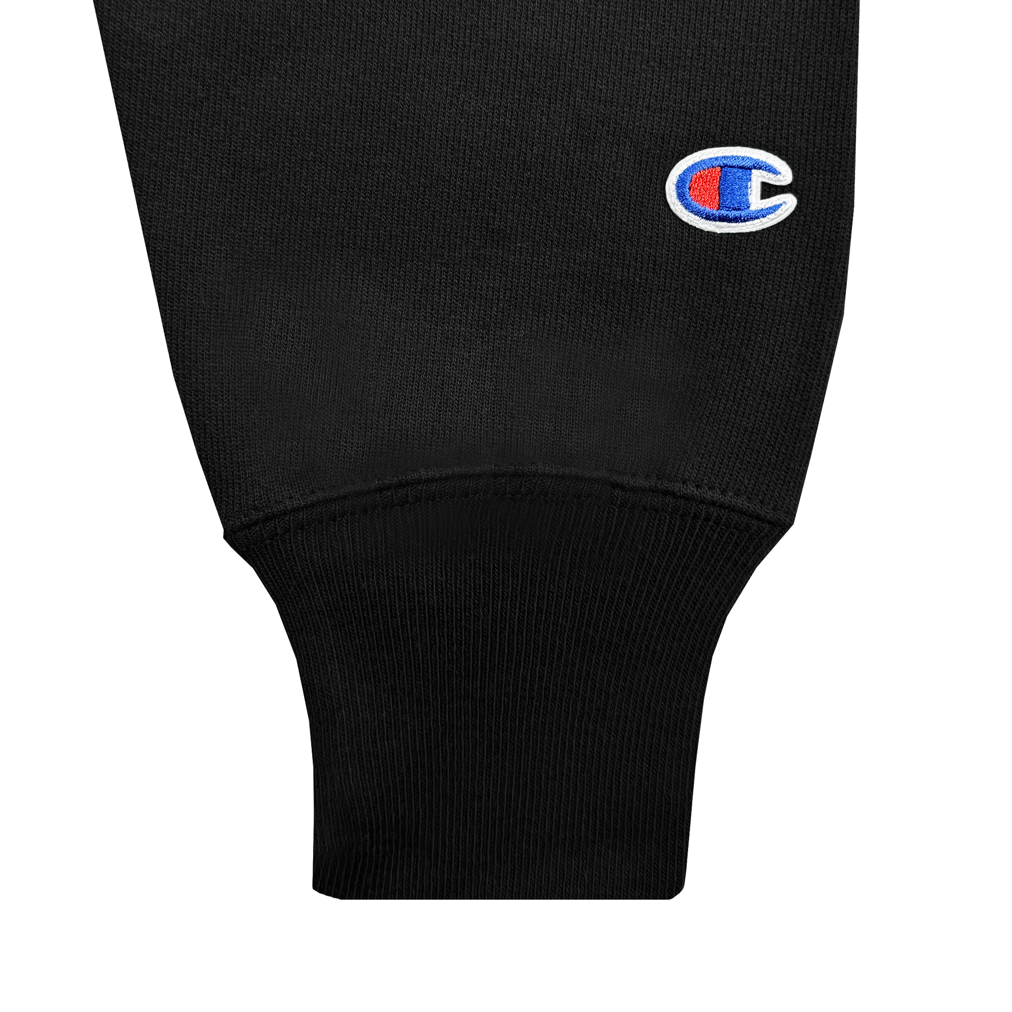 Close-up of a black sleeve cuff with ribbed detailing from the Champion X Oakland Ballers Wordmark Hoodie. The sleeve displays the Champion logo, an embroidered "C" in red, white, and blue, near the hem. Texture and stitching highlight the garment's quality.