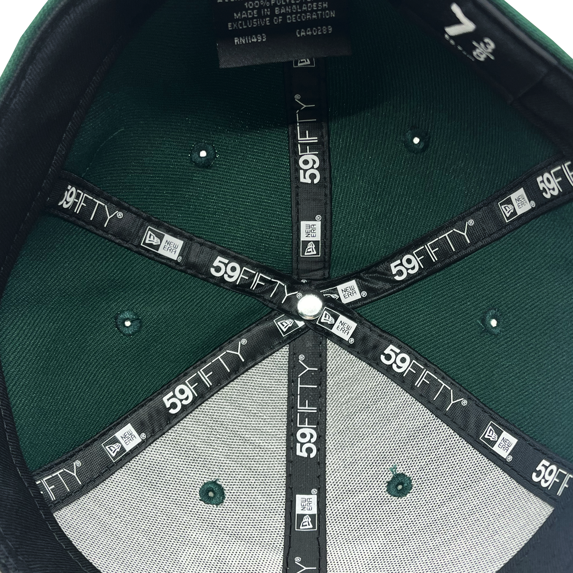 The image showcases the inner view of the New Era Oakland Ballers Low Profile 59FIFTY Cap, featuring 59FIFTY branding on the inner seams. The cap has black linings accented with white text and symbols, a silver button at the center, and a predominantly green top. The size "7 3/8" is clearly marked along with a tag indicating it is made in Bangladesh. It's perfect for any fan of the Oakland Ballers.