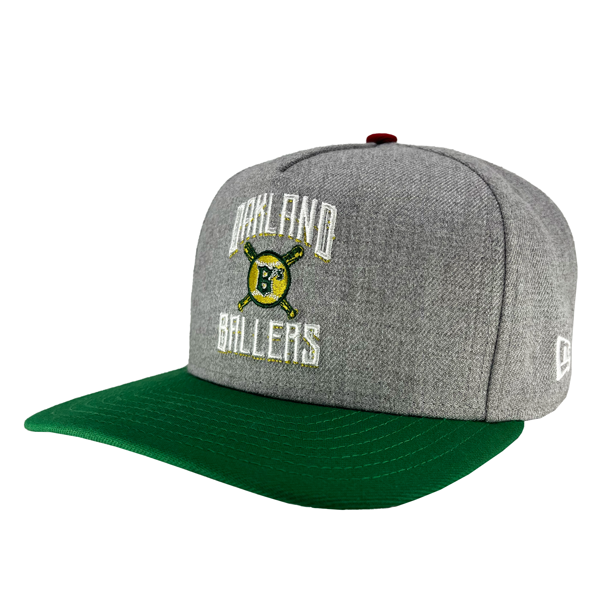 Introducing the New Era Oakland Ballers Alt Logo 9FIFTY AF Cap from Oakland Ballers. This stylish cap boasts a gray body with a green brim and features "Oakland Ballers" embroidered in white letters on the front. At its center, an intricate design of a baseball logo with crossed bats and a capital "B" is set against a yellow and green circular background, celebrating Oakland's new Pro Baseball Team in the Pioneer League. The side of the cap proudly displays the iconic white New Era logo.