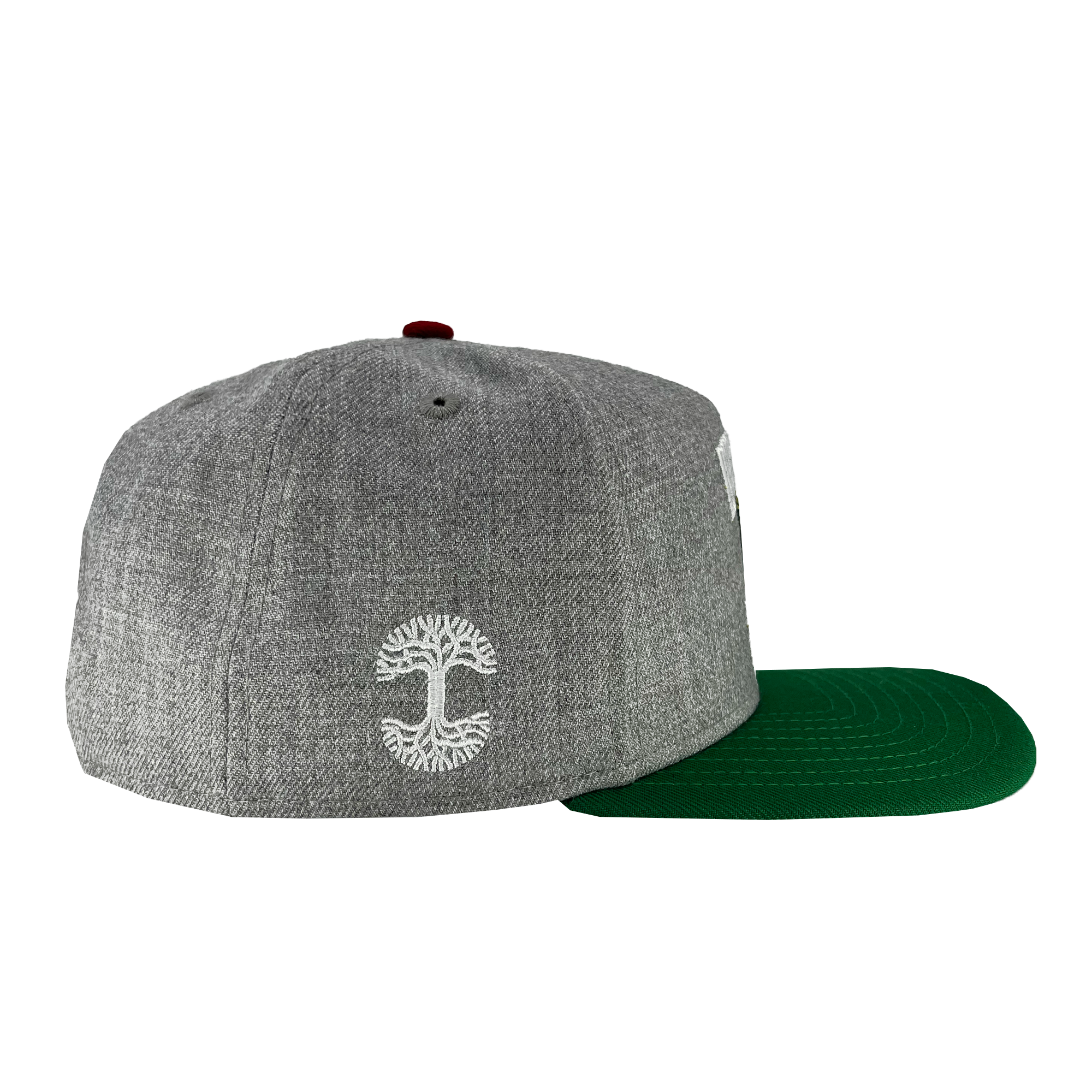 Introducing the New Era Oakland Ballers Alt Logo 9FIFTY AF Cap. This stylish cap, crafted by Oakland Ballers, features a gray flat brim with a green underside and a maroon button on top. The back showcases a white embroidered symbol resembling a stylized tree or mushroom design, possibly hinting at Oakland's New Pro Baseball Team. Made from textured fabric, this cap offers both style and durability.