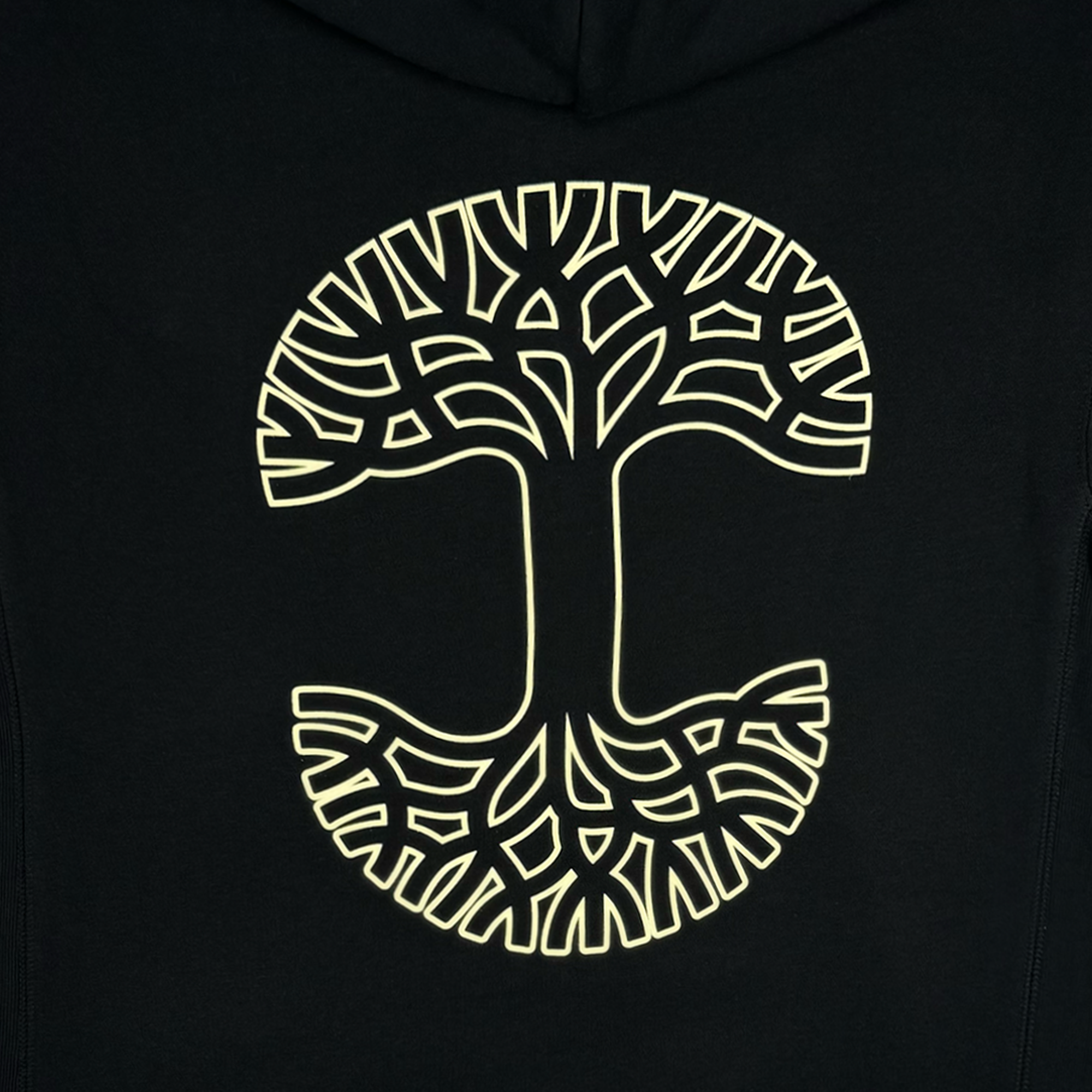 The Bandit Hoodie by Oaklandish, available in men's sizing, features a stylized circular tree design with a glowing yellow outline on the back. The symmetrical pattern of branches and roots stands out dramatically against the dark fabric, creating a striking visual contrast.