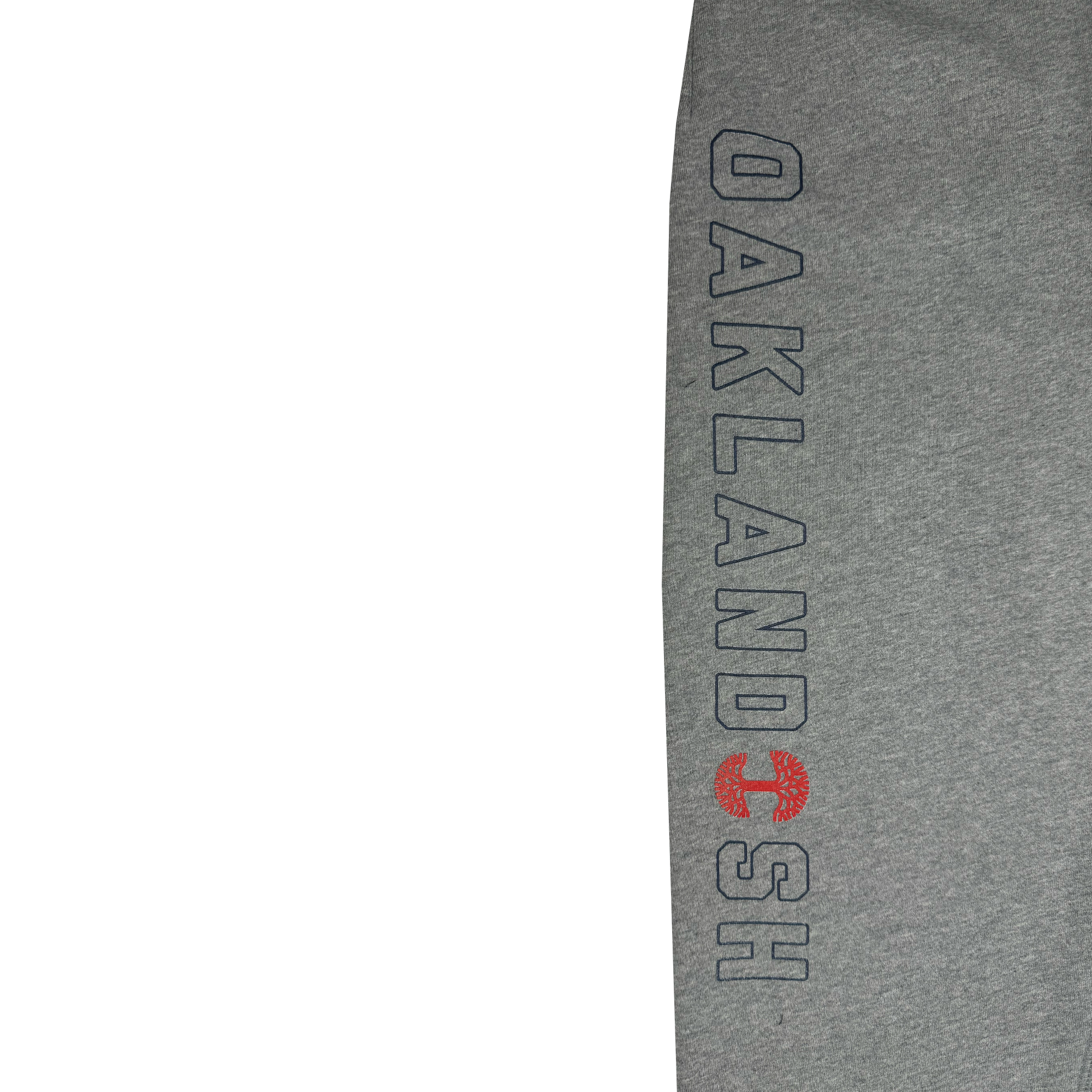 A close-up of the Bandit Sweatpants, showcasing gray fabric with "OAKLANDISH" in large, vertically aligned dark letters. The letter "A" is substituted with a distinctive red circular tree logo. A hidden zipper pocket adds a unique detail to the design, while ample white space adorns the left side.