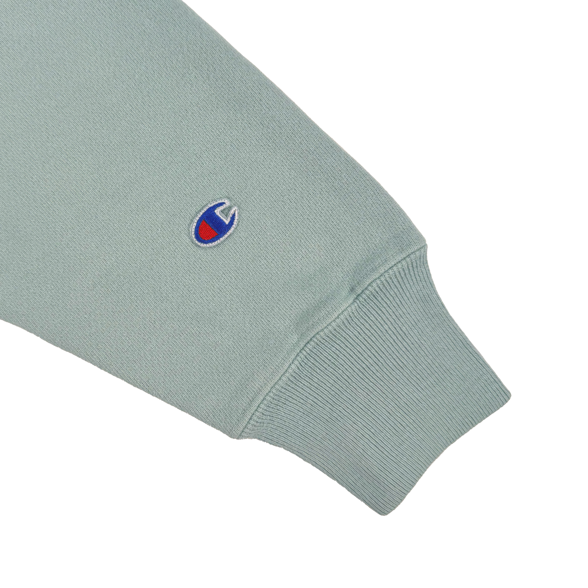 The Champion X Oakland Soul Wordmark Crew showcases a light green long-sleeve with ribbed cuffs and an embroidered blue and red "C" logo near the cuff. Crafted from soft, cotton-like fabric, it's perfect for supporting the Oakland Soul women's soccer team in style and social good spirit.