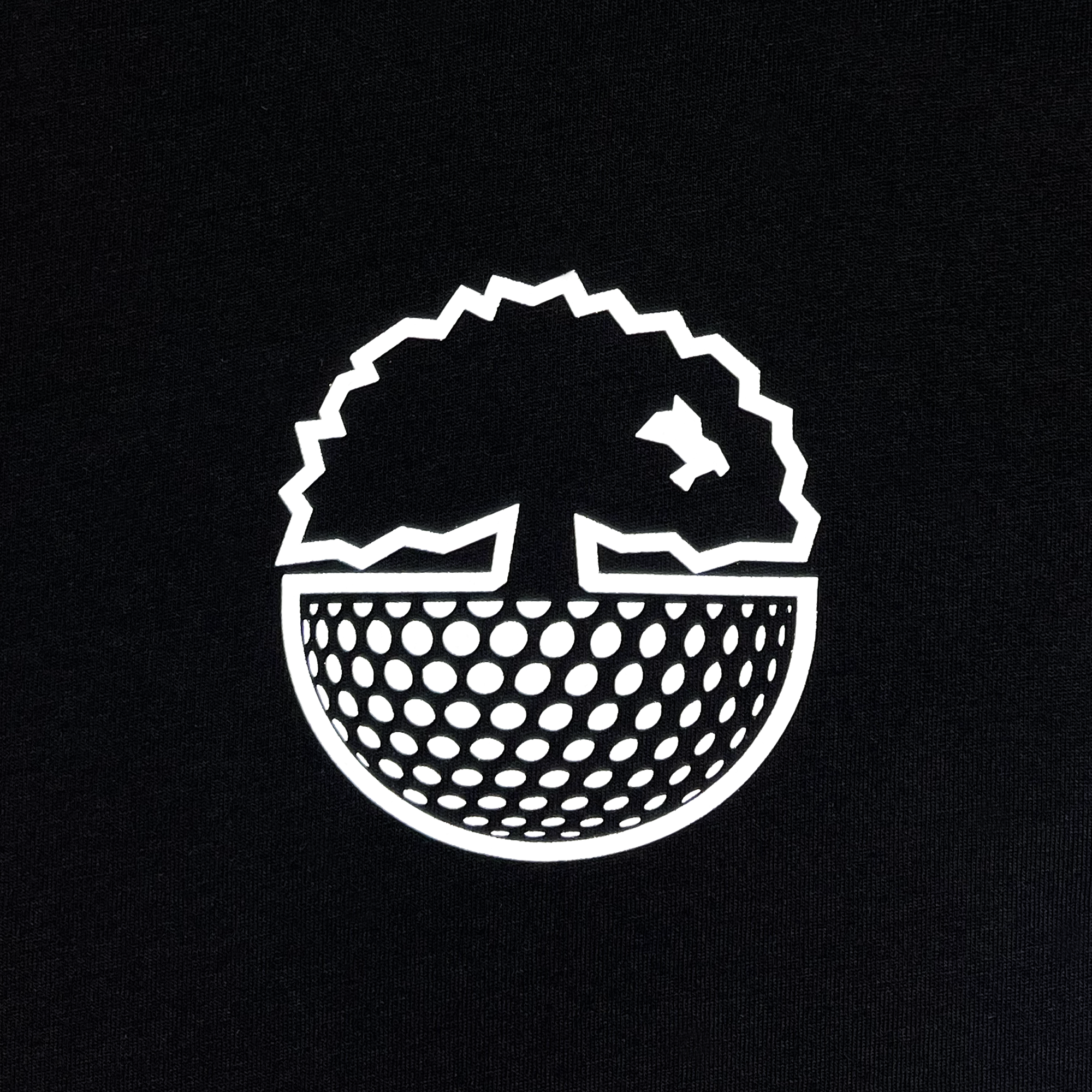 The Oakland Roots SC's Golf Origins Tee showcases a striking white logo set against a black backdrop, featuring a stylized tree with jagged edges. Below the tree, the design transitions into a dome crafted from numerous small, evenly spaced circles that mimic the look of a halftone pattern. A small bird flying near the tree's right side symbolizes Oakland Roots Sports Club's dedication to social good.