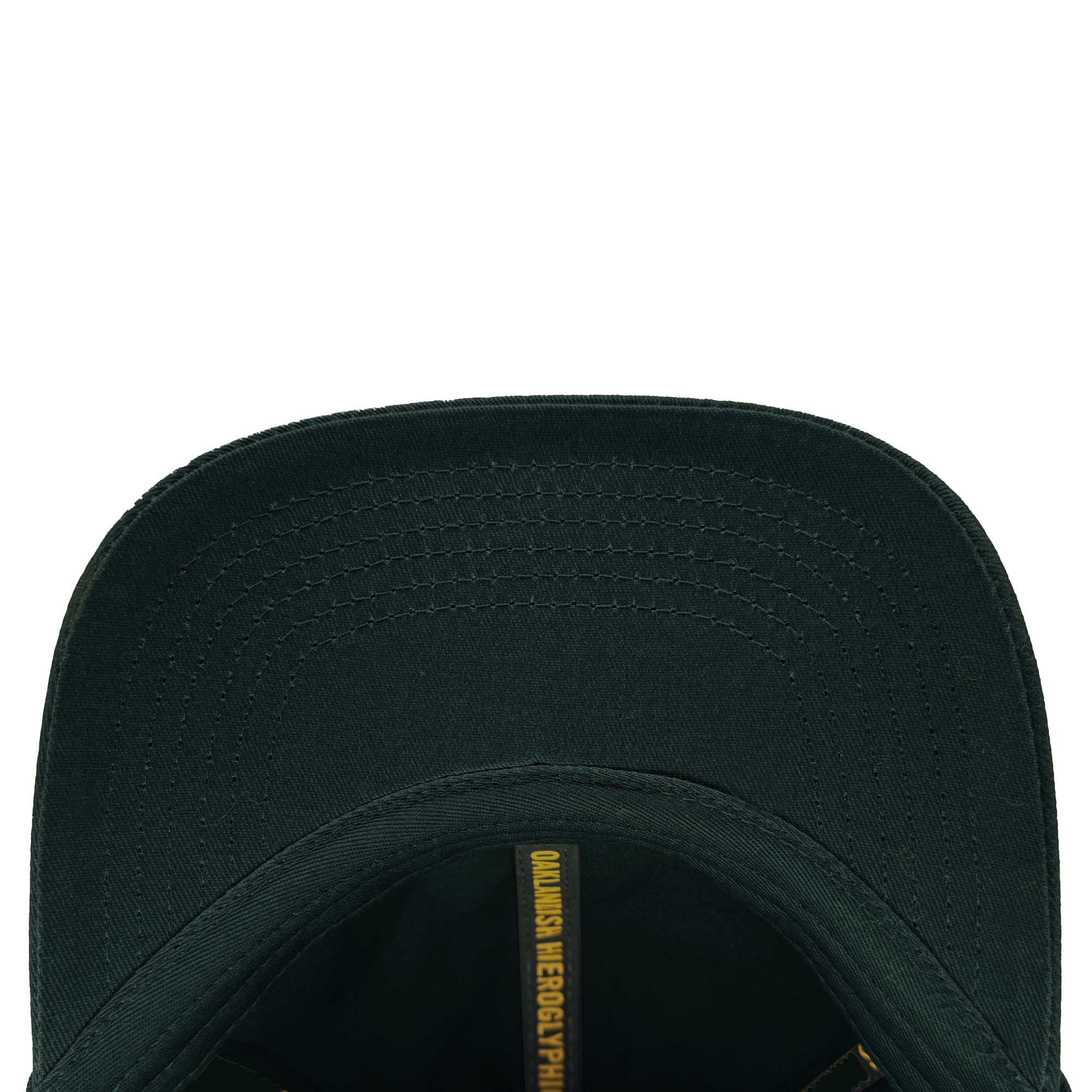 Top view of the Hieroglyphics Hiero Logo Dad Hat shows the inside brim with a darker green shade and visible stitching. Inside, an adjustable strap enhances comfort, while a yellow strip features partially visible black text "QUANSIS NEGROPYHIC," resembling modern hieroglyphics.