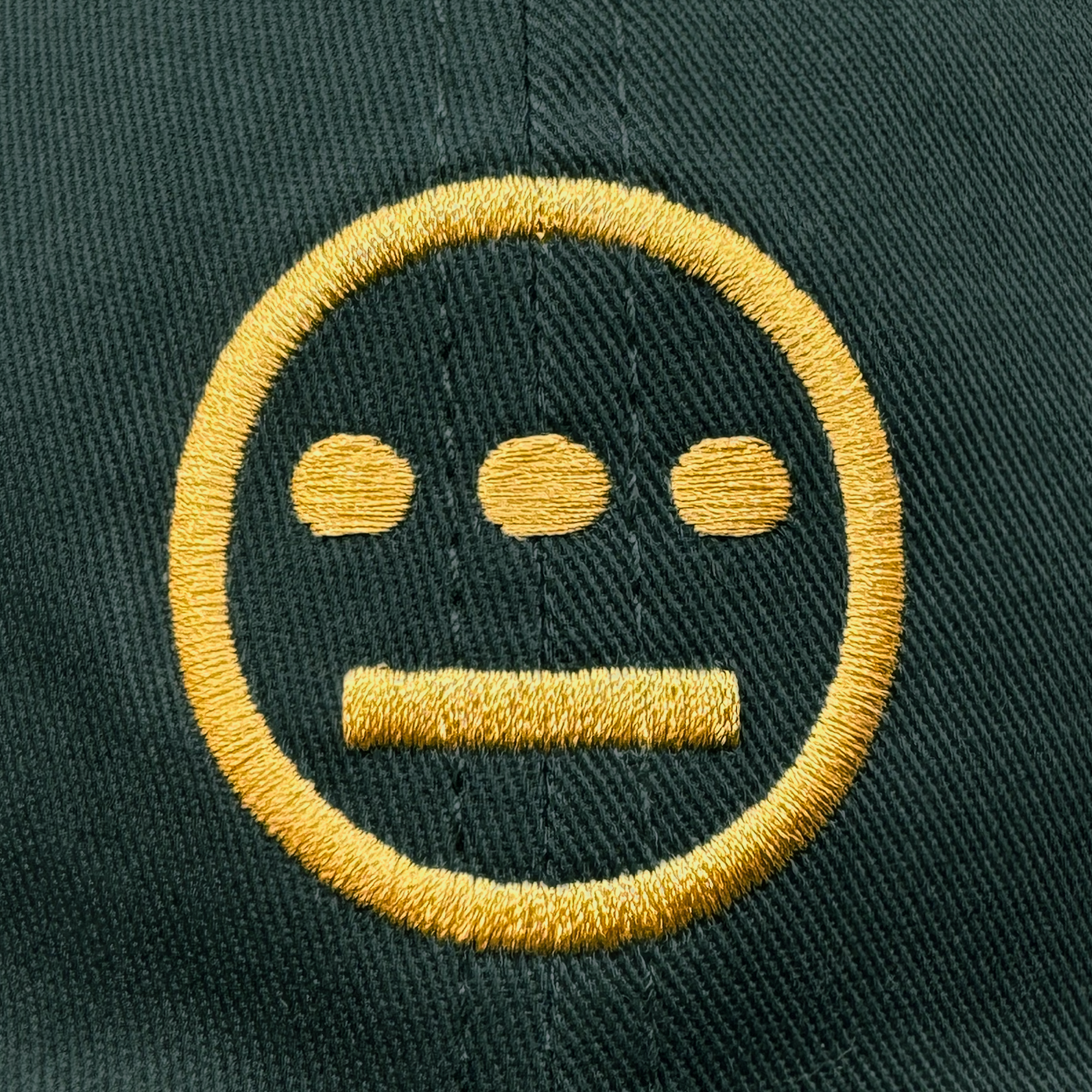 The Hieroglyphics "Hiero Logo Dad Hat" features a dark green hue with a yellow embroidered hieroglyph-like symbol, showcasing a bold circle enclosing three horizontal dots above a line. It has detailed stitching and an adjustable strap back for added style and comfort.