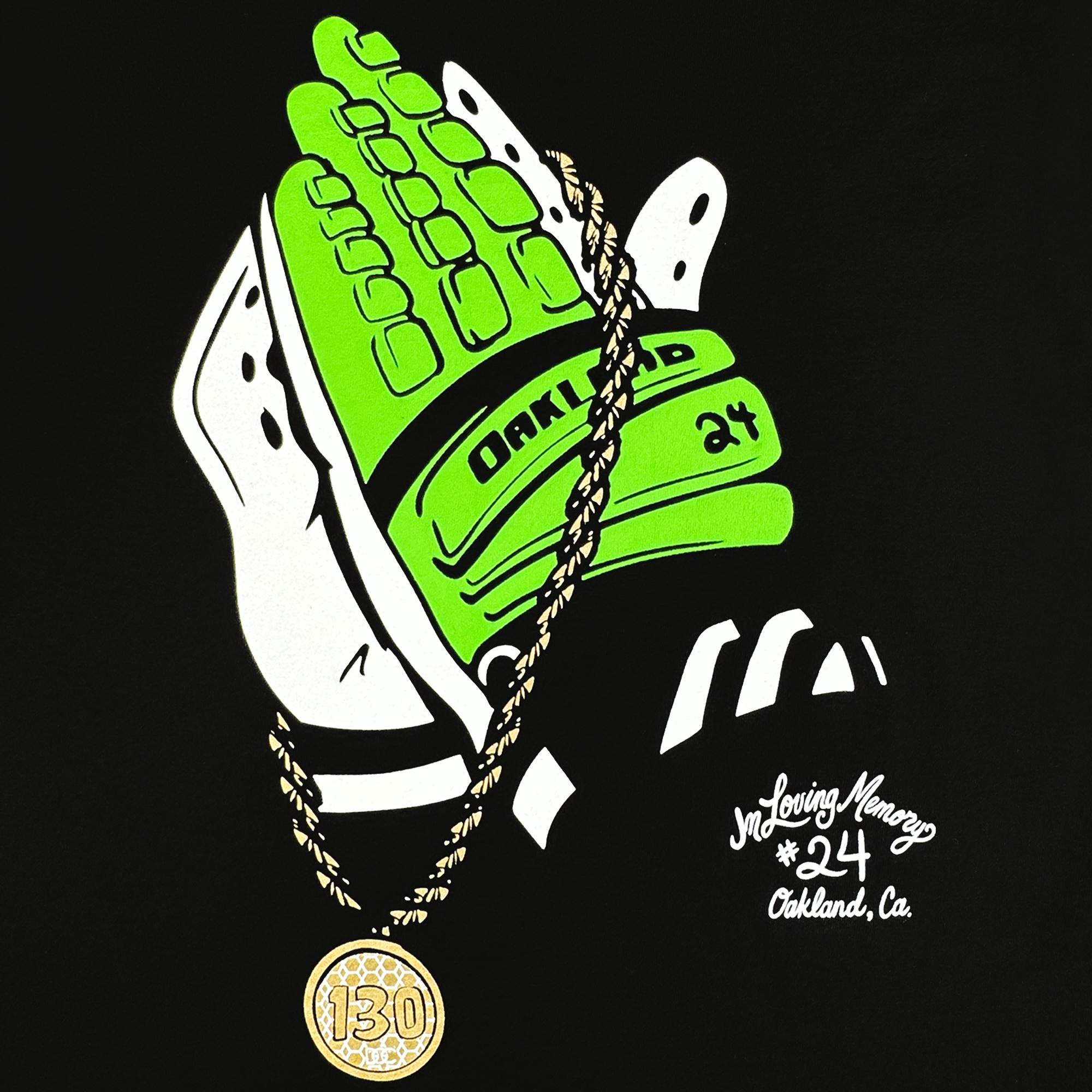 The "RIP Man of Steal" t-shirt by Oaklandish features a green and white baseball glove holding a "130" pendant gold chain. The glove displays "Oakland A’s," number "24," and text saying "In Loving Memory" and "Oakland, Ca.," making this homage perfect for a solid black classic fit tee.