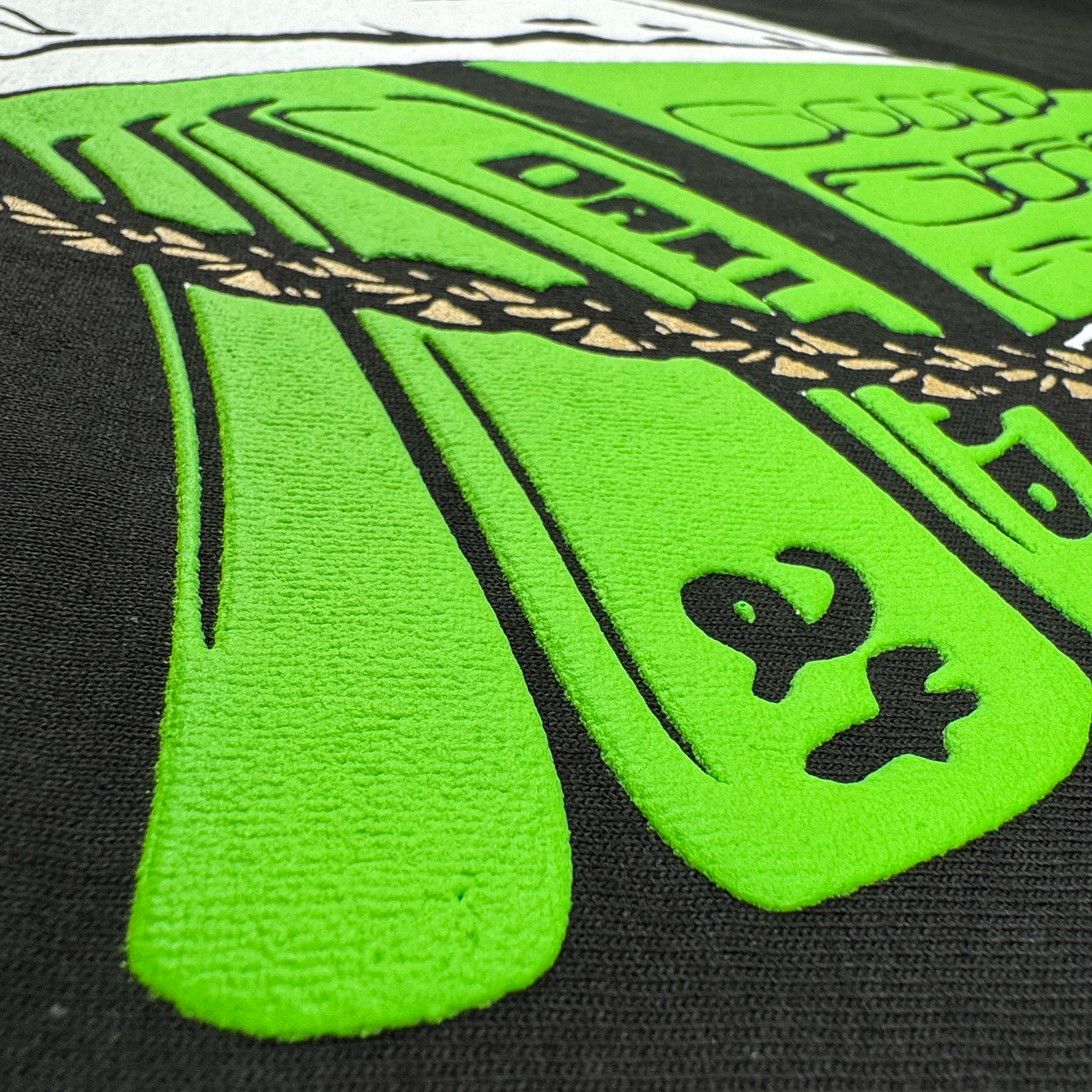 The (Preorder) RIP Man of Steal Men's T-shirt by Oaklandish features a close-up graphic with a stylized green hand and rope patterns on black fabric. Bold lines and textures frame the "Oakley" text and "24", resembling an Oakland A's tribute with vibrant colors against the dark background.