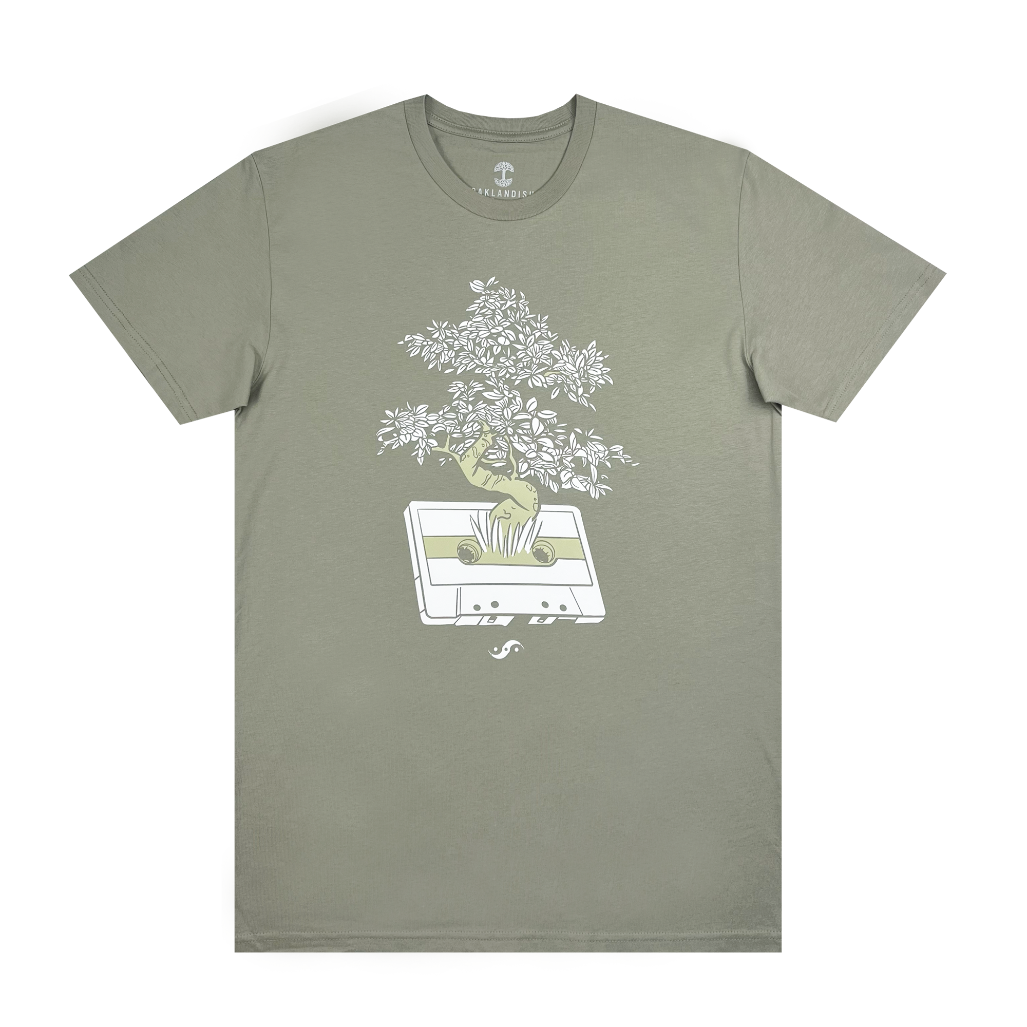 The Out the Trunk Bonsai Tee by Oaklandish is a sage-green, short-sleeved t-shirt with a round neck. It features a graphic design of a vintage cassette tape from which plants and flowers appear to grow, capturing the vibrant spirit of Oakland.