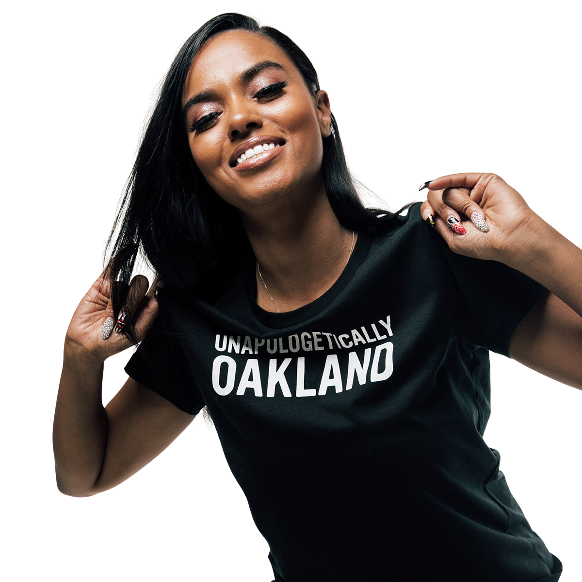 A smiling person with long black hair wears Oaklandish's Unapologetic Tee, a 100% cotton black T-shirt featuring "Unapologetically Oakland" in white text, as they hold the collar with both hands against a black background.