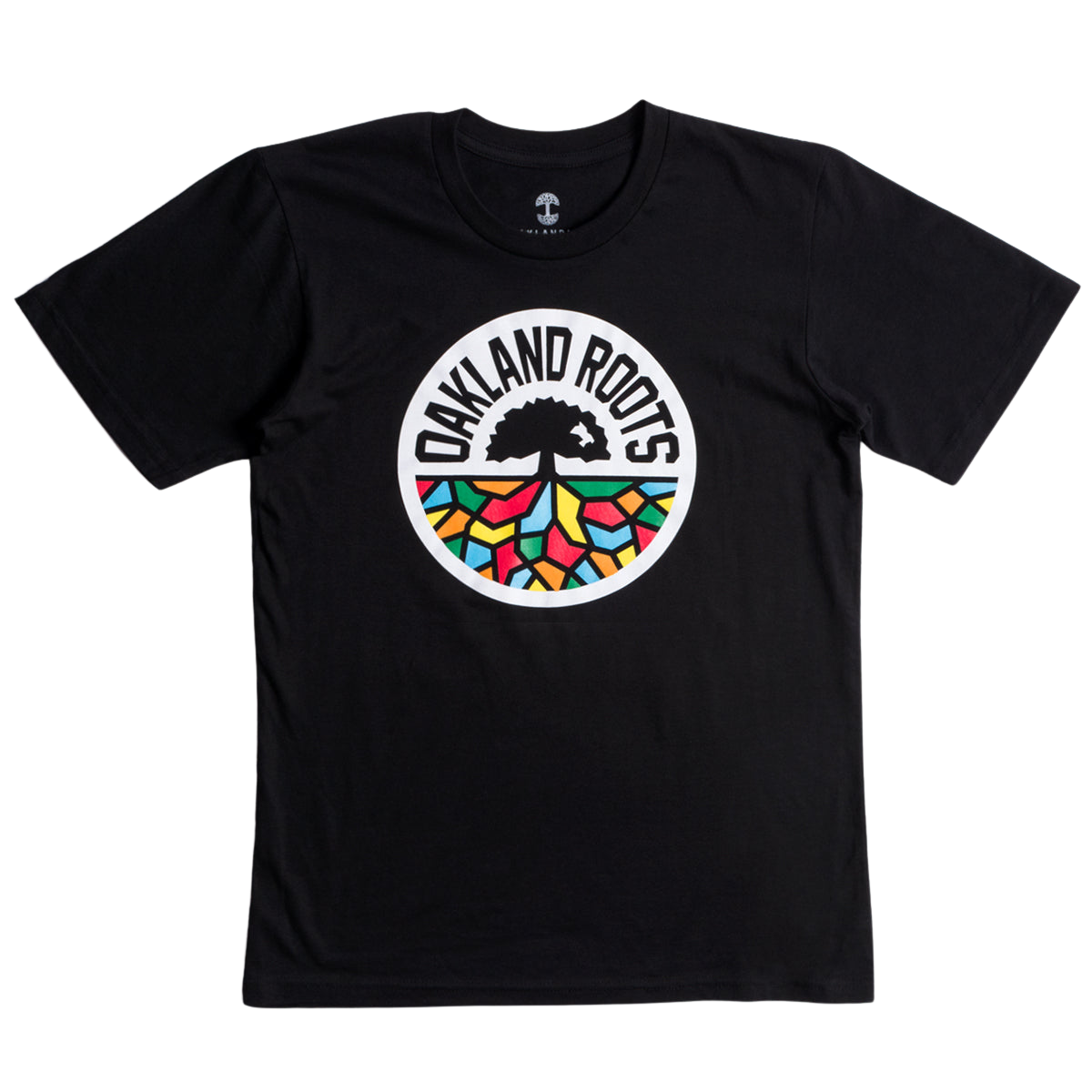 The Oakland Roots SC Classic Tee by Oakland Roots SC is a black t-shirt featuring a circular logo in the center. The logo displays a black tree encircled by the text "OAKLAND ROOTS" in white. Beneath the tree's roots, you'll find colorful geometric shapes in red, green, yellow, and blue, symbolizing the social good values of Oakland Roots Sports Club.