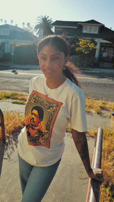 Girl wearing natural tee from the BPPALN x Obey collection, outdoors, walking and posing.