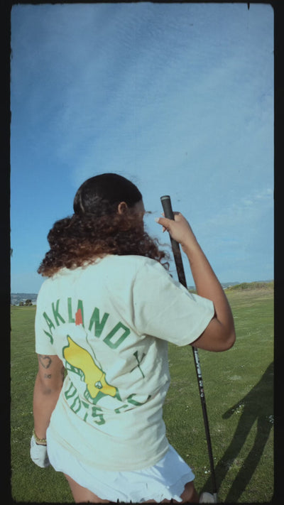 Guy and girl model on golf course in Ecru tees.