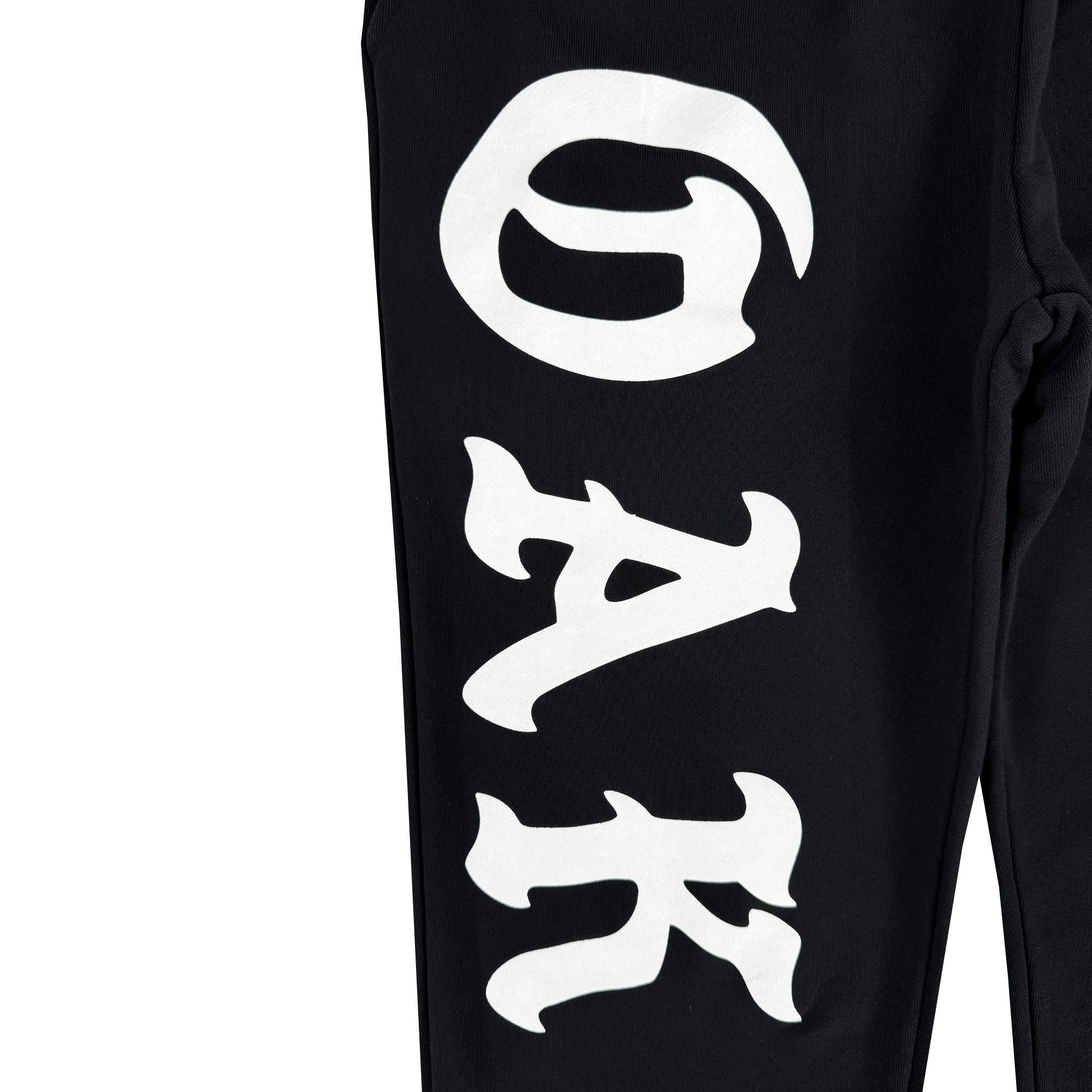 The close-up of the black Oaklandish Roble Joggers showcases bold, stylized white letters "G A K" vertically on one leg. The wavy, artistic design contrasts against the dark fabric, accentuating the lettering while keeping the rest of these men's sizing bottoms partially visible.