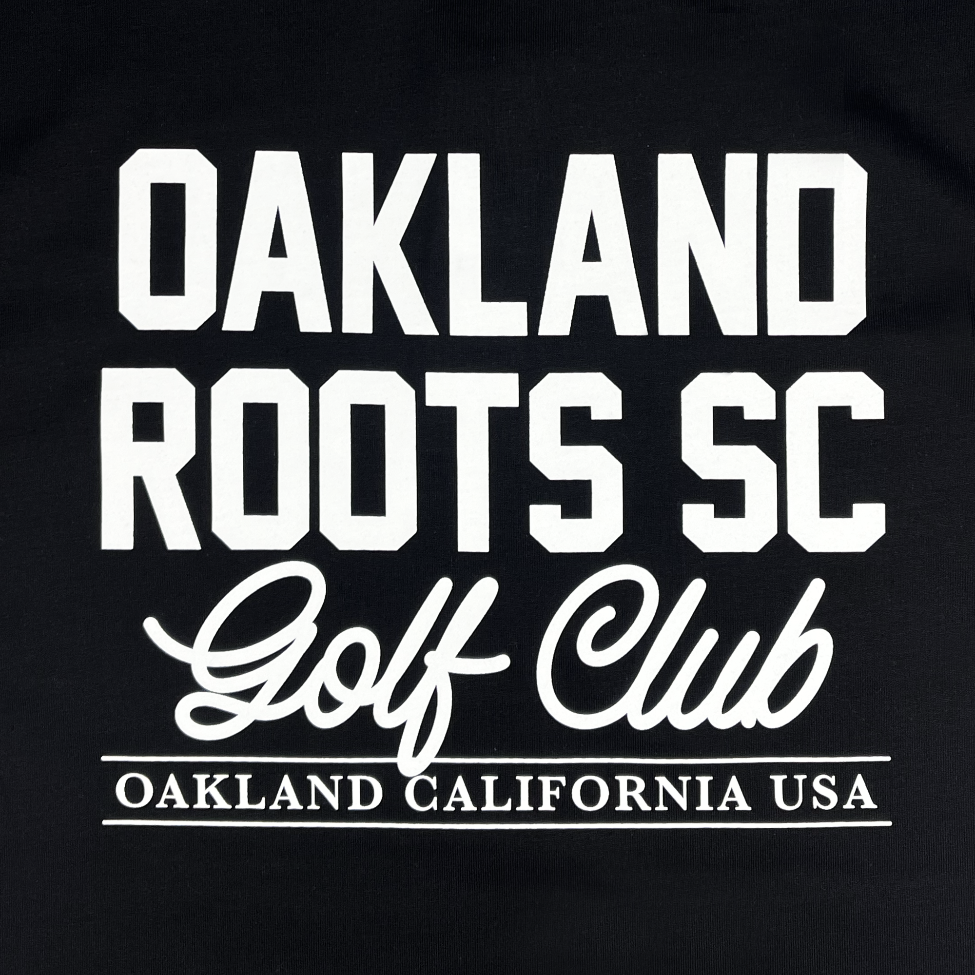 Black background with bold white text in two typography styles. The top part reads "Oakland Roots SC" in a block font, with "Members Only Polo" in a script font underneath. The bottom line reads "OAKLAND CALIFORNIA USA" in capital letters, celebrating the sports club's dedication to social good.