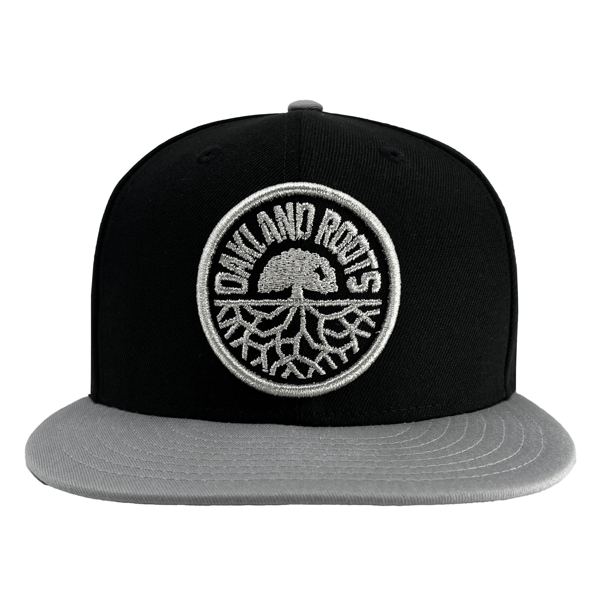 The New Era Oakland Roots SC 9FIFTY Cap by Oakland Roots SC features a black crown and flat gray brim. It showcases the club's circular emblem on the front, which includes an oak tree and roots graphic encircled by the text "OAKLAND ROOTS.