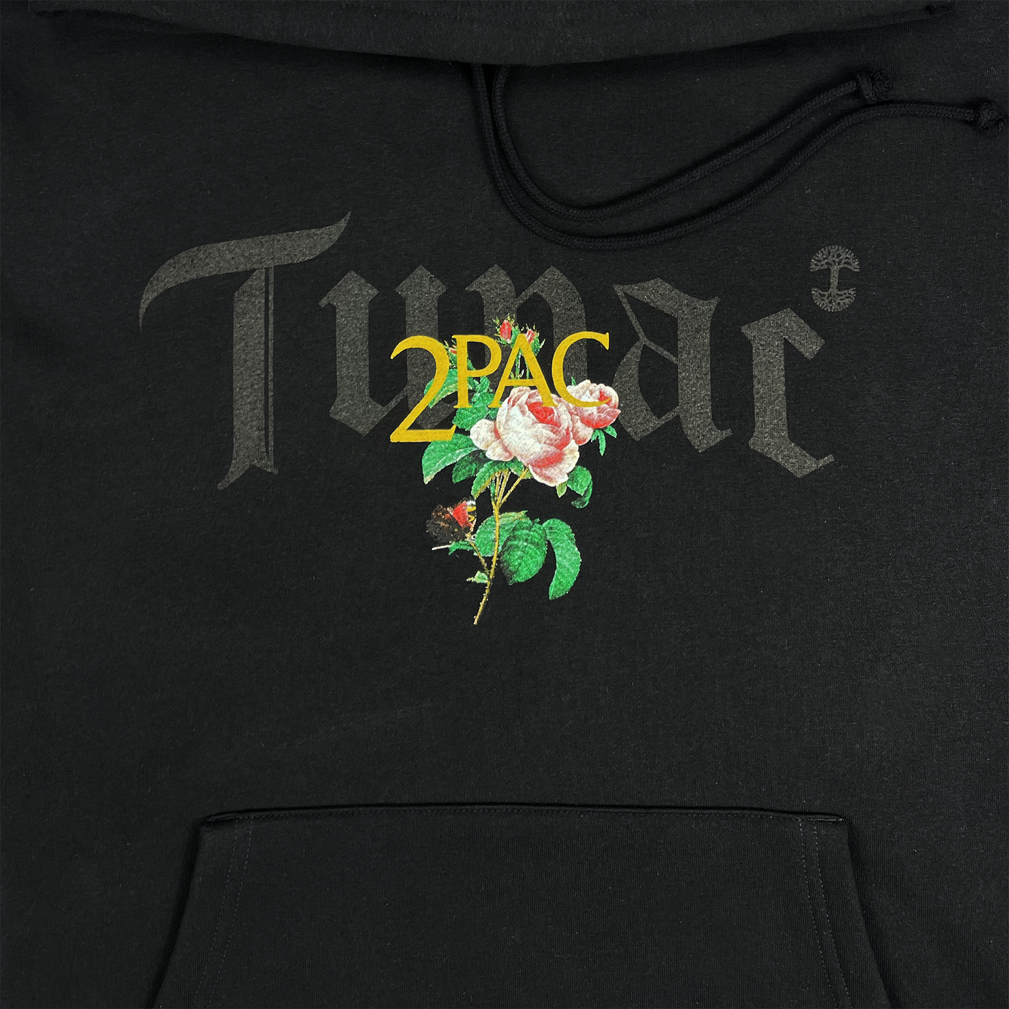 The Roses Hoodie from Oaklandish's Tupac hip-hop collection showcases the word "TUPAC" in striking dark gray ornate text, accompanied by a vivid pink rose with green leaves and highlighted by the bright yellow text "2PAC," all capturing the essence of Tupac's legacy. The front pocket subtly appears at the bottom of the hoodie.