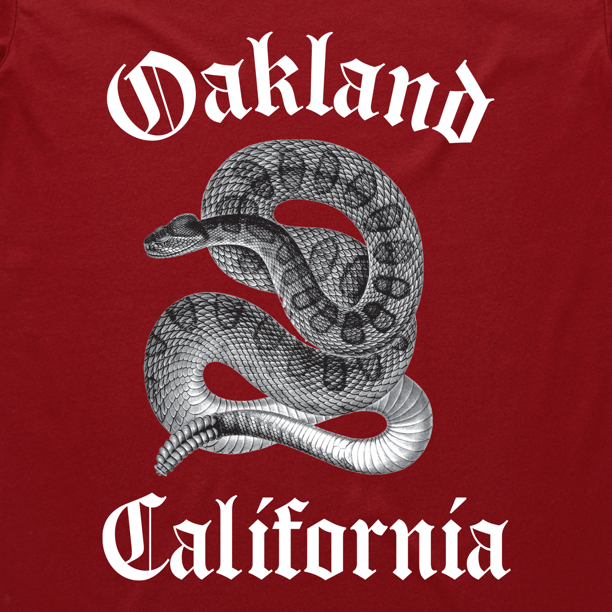 The Sistrurus Tee by Oaklandish features a detailed illustration of a coiled snake in shades of gray and black on a dark red background. "Oakland California" is boldly inscribed in white Gothic lettering. This classic fit t-shirt is crafted from 100% cotton, offering both comfort and style.