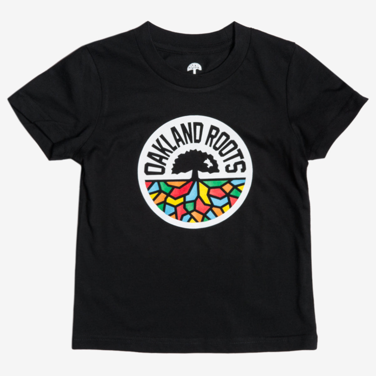 The Toddler Oakland Roots SC Classic Tee from Oakland Roots SC is a black T-shirt that prominently features a circular logo in the center. This logo showcases a black tree silhouette above bold, block letters spelling “OAKLAND ROOTS,” with colorful, abstract shapes resembling stained glass in red, yellow, green, and blue beneath the text—a perfect fit for any young fan of this vibrant sports club.