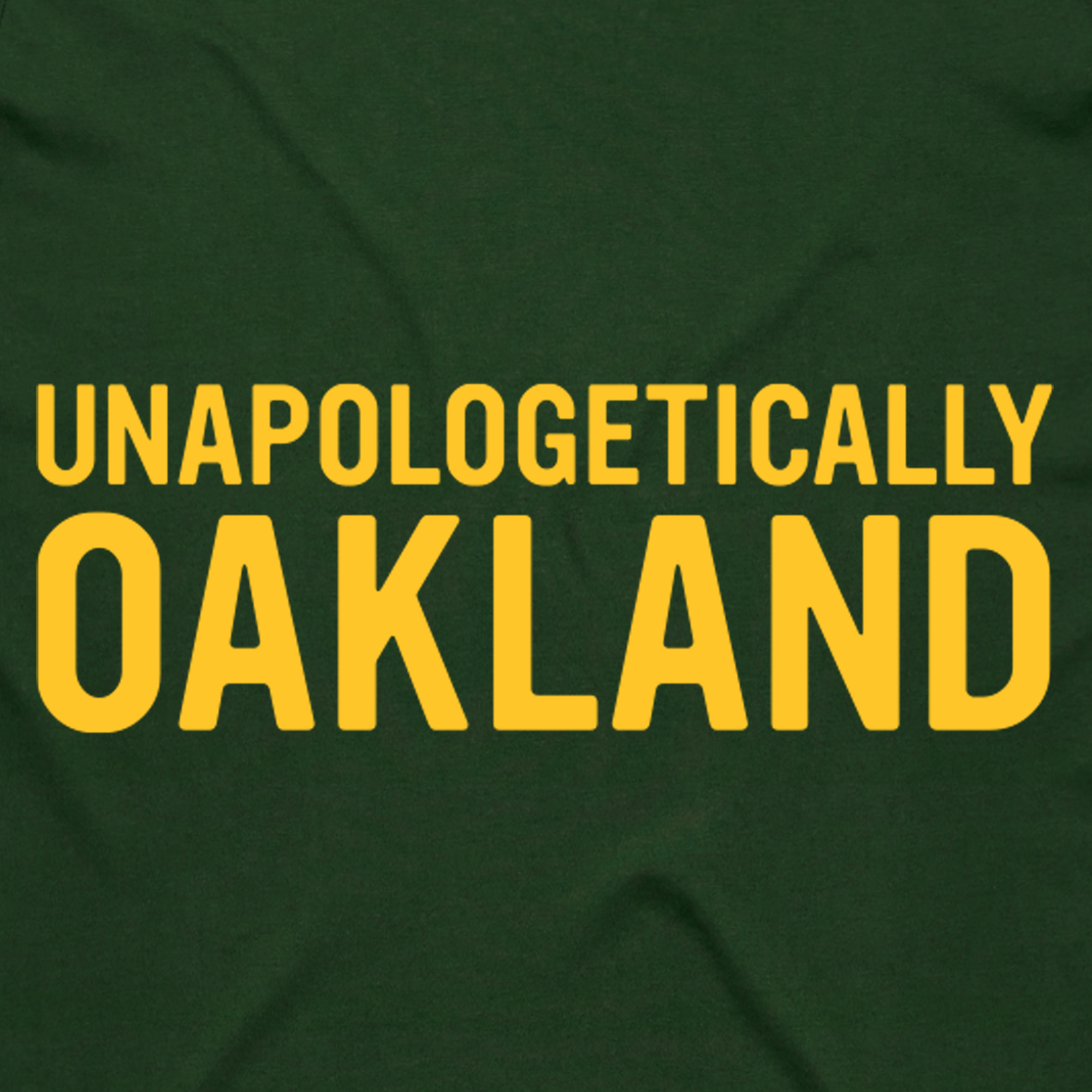 The image features "Unapologetically Oakland" in bold yellow on dark green, centered for visual appeal. This design is on the Unapologetic Tee by Oaklandish, a men's classic fit t-shirt made from 100% cotton for comfort and style.